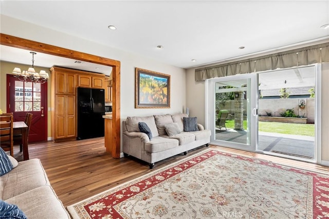 living room with a chandelier, recessed lighting, and wood finished floors