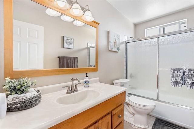 bathroom with combined bath / shower with glass door, tile patterned floors, vanity, and toilet