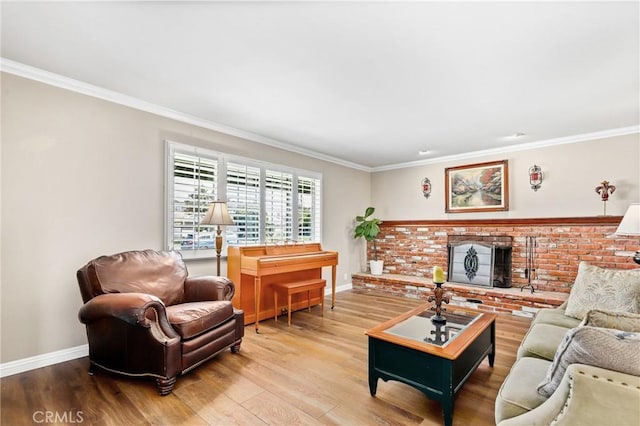 living area with a fireplace, baseboards, ornamental molding, and wood finished floors