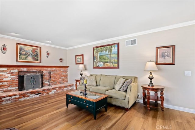 living room featuring wood finished floors, baseboards, ornamental molding, and visible vents