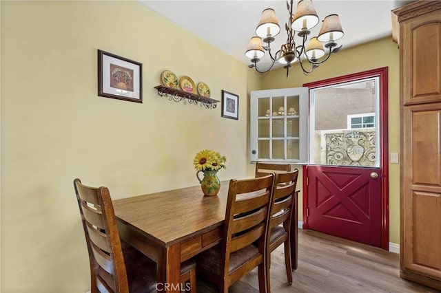 dining room featuring wood finished floors and a notable chandelier