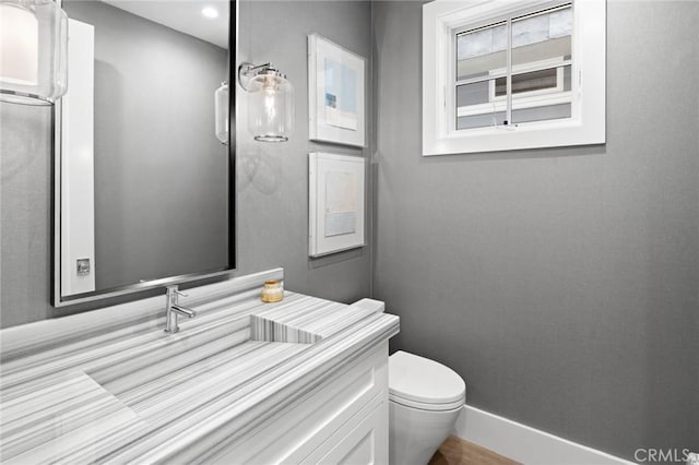 bathroom featuring recessed lighting, vanity, baseboards, and toilet