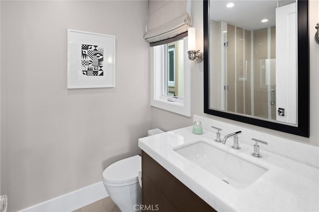 bathroom with vanity, recessed lighting, toilet, an enclosed shower, and baseboards