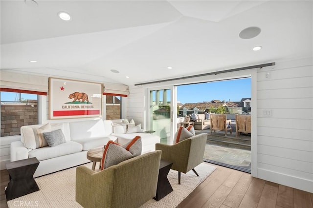 living area featuring hardwood / wood-style floors, recessed lighting, lofted ceiling, and a wealth of natural light