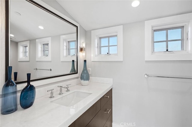bathroom featuring recessed lighting, vanity, and vaulted ceiling