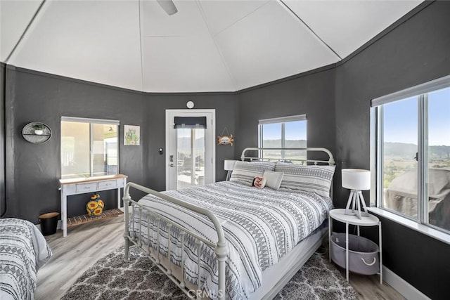 bedroom featuring ensuite bath, wood finished floors, and lofted ceiling