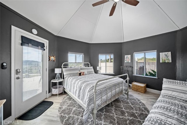 bedroom featuring baseboards, vaulted ceiling, access to exterior, ceiling fan, and wood finished floors