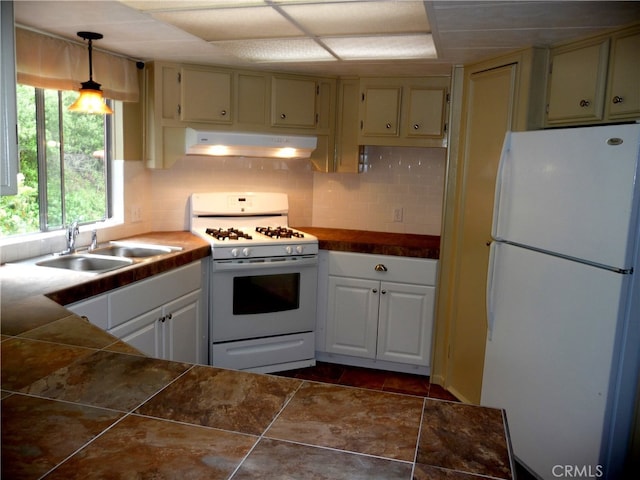 kitchen featuring tile counters, white appliances, under cabinet range hood, decorative backsplash, and a sink
