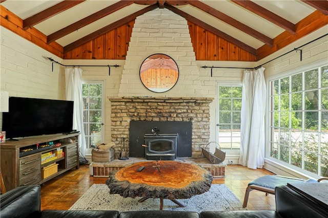 living room with wood finished floors, lofted ceiling with beams, and a healthy amount of sunlight