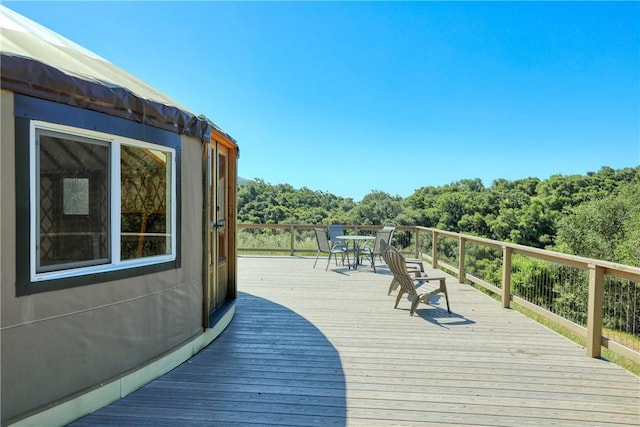 wooden terrace with a view of trees