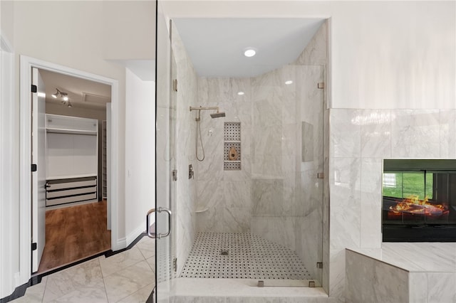 full bathroom featuring baseboards, marble finish floor, and a stall shower