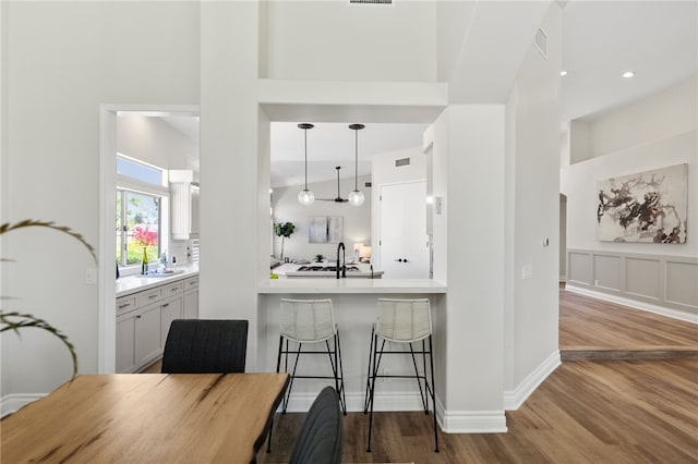 38027 Cherrywood Dr, Murrieta, CA 92562 - kitchen with wood finished floors, light countertops, decorative light fixtures, white cabinetry, and decorative backsplash
