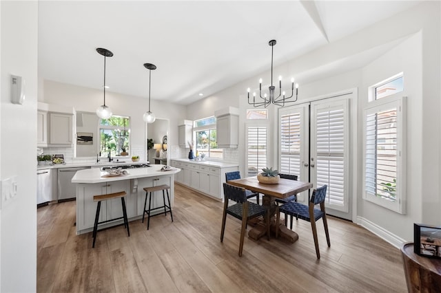 dining area with light wood-type flooring and a notable chandelier