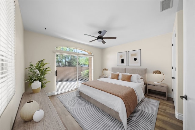 bedroom featuring wood finished floors, visible vents, baseboards, and access to exterior