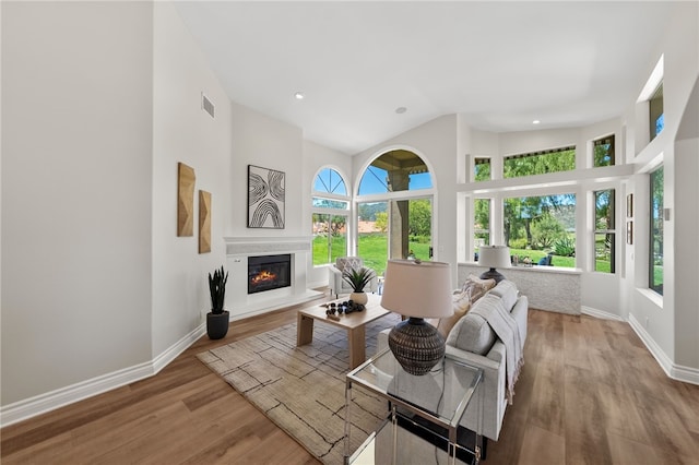 38027 Cherrywood Dr, Murrieta, CA 92562 - living area featuring a glass covered fireplace, a high ceiling, wood finished floors, and recessed lighting