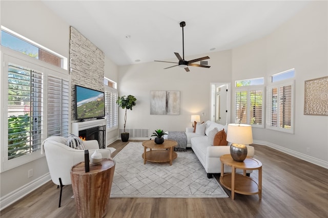 living area featuring a high ceiling, wood finished floors, and a wealth of natural light