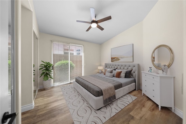 bedroom with baseboards, lofted ceiling, ceiling fan, and light wood-type flooring