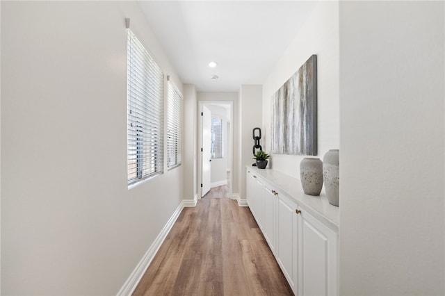 hallway with baseboards and light wood-style flooring
