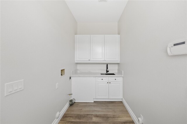 laundry area featuring a sink, hookup for a washing machine, light wood-style flooring, baseboards, and hookup for a gas dryer