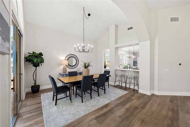 dining room with a chandelier, wood finished floors, visible vents, and baseboards