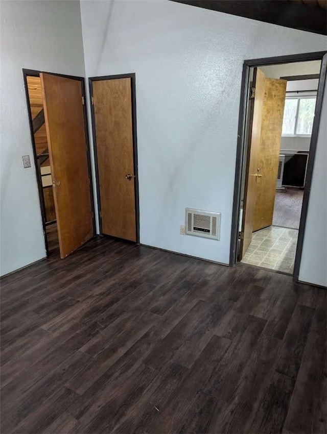 unfurnished bedroom featuring a textured wall, wood finished floors, and visible vents