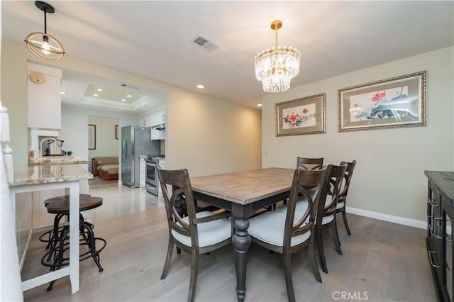 dining area with a chandelier, light wood-style flooring, recessed lighting, baseboards, and visible vents