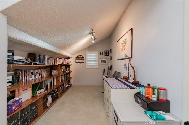 interior space featuring light colored carpet, a textured ceiling, vaulted ceiling, and baseboards