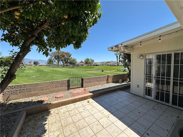 view of patio with fence and view of golf course