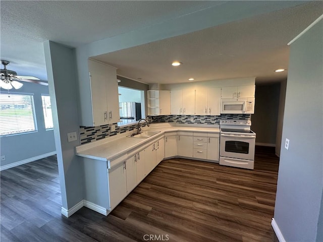 kitchen featuring tasteful backsplash, white appliances, white cabinetry, and a sink
