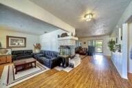 9975 Custer Ave, Lucerne Valley, CA 92356 - living area featuring a fireplace with raised hearth and wood finished floors