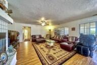 9975 Custer Ave, Lucerne Valley, CA 92356 - living area with wood finished floors, a brick fireplace, and a wealth of natural light