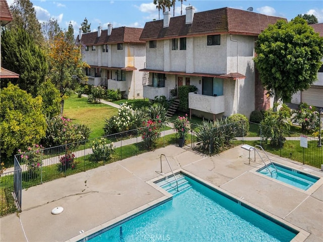 community pool with a community hot tub and a patio area