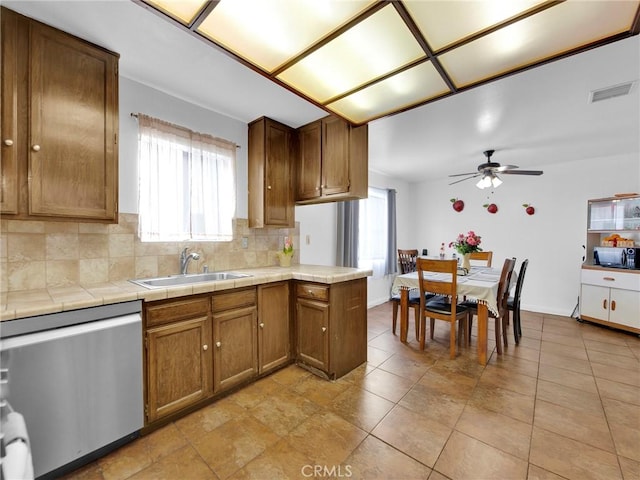 kitchen with dishwasher, a sink, ceiling fan, and decorative backsplash