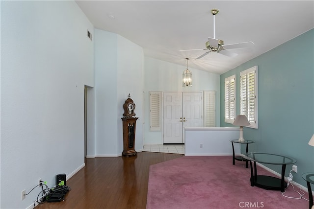living area featuring visible vents, baseboards, wood finished floors, and ceiling fan with notable chandelier