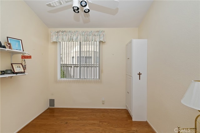 empty room featuring baseboards, a ceiling fan, and wood finished floors