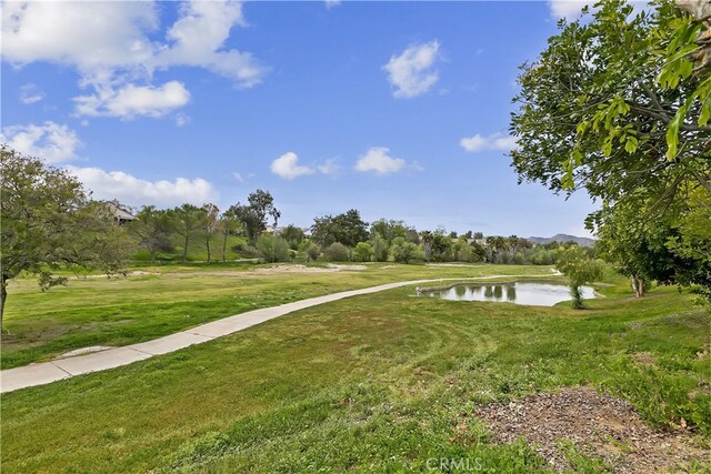 view of property's community featuring a water view and a lawn