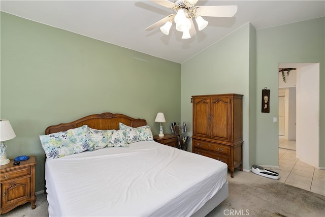 bedroom with high vaulted ceiling, ceiling fan, light carpet, light tile patterned flooring, and baseboards