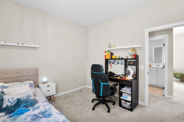 carpeted bedroom with a sink and baseboards