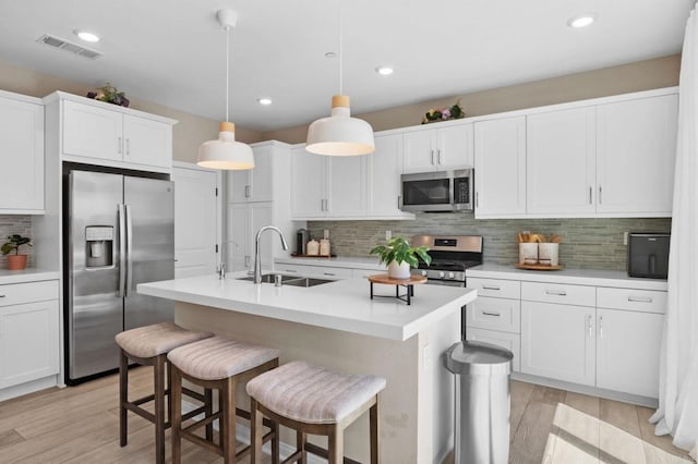 1751 Whitmore Loop, Chula Vista, CA 91913 - kitchen featuring appliances with stainless steel finishes, a sink, white cabinetry, backsplash, and a breakfast bar area