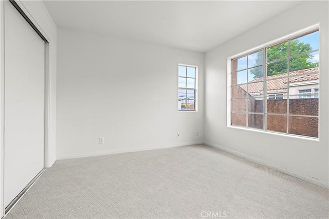 unfurnished bedroom with a closet, carpet flooring, and baseboards