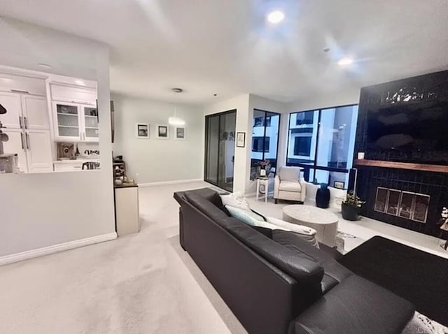 living area with light carpet, a fireplace, and baseboards