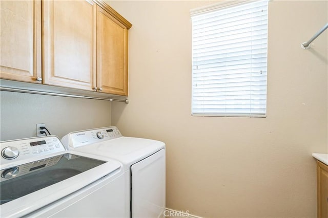 washroom featuring independent washer and dryer and cabinet space