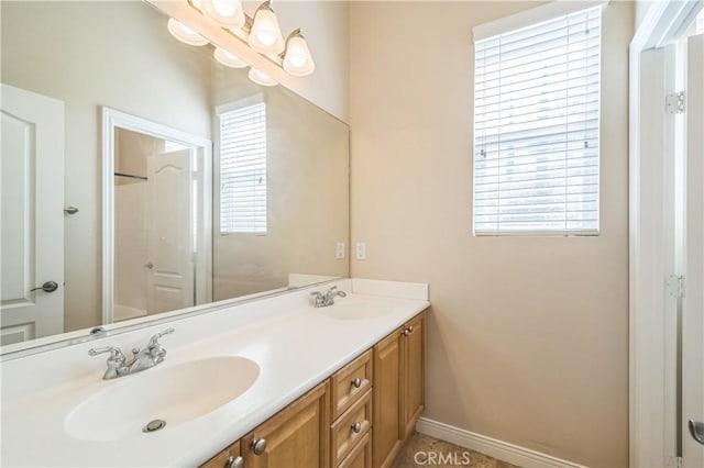 bathroom featuring a healthy amount of sunlight, double vanity, and a sink