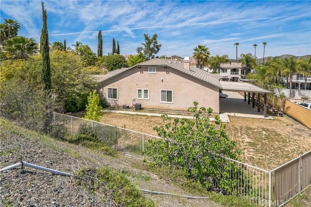 view of side of home featuring stucco siding and fence