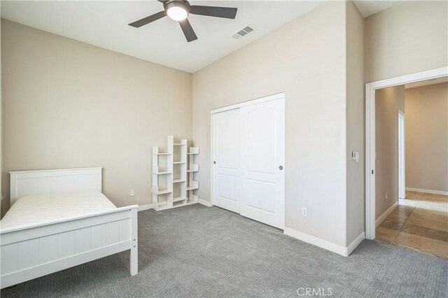unfurnished bedroom featuring carpet, visible vents, a closet, and baseboards