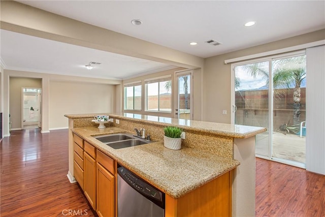 kitchen featuring dishwasher, a sink, dark wood-style flooring, a kitchen island with sink, and light stone countertops