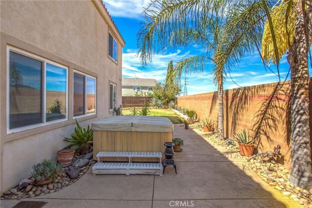 view of patio / terrace featuring a fenced backyard and a hot tub