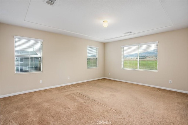 carpeted empty room with visible vents and baseboards