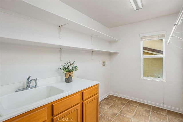 laundry area with laundry area, washer hookup, a sink, and baseboards