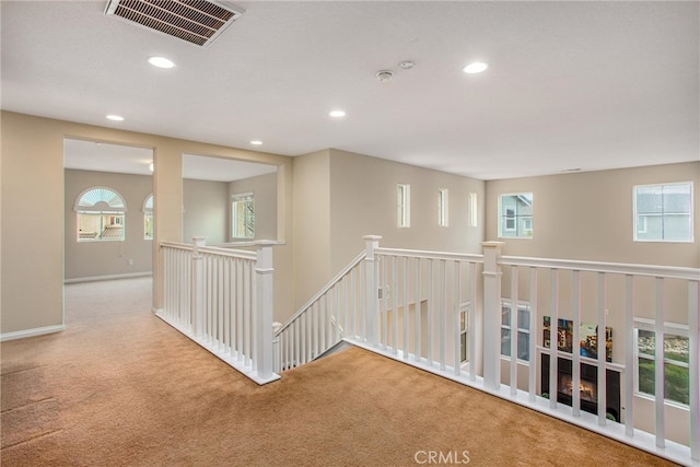 hall with visible vents, recessed lighting, an upstairs landing, and carpet floors